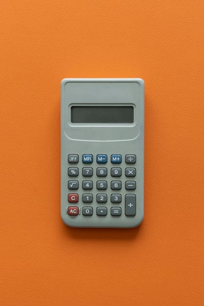 Person looking confused at calculator and spreadsheet, representing common questions about CPM calculations